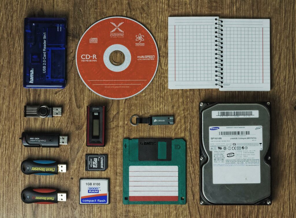 A picture showing a bunch of devices and tools (CD, flash memory, hard disk, usb memory, notebook) to store data